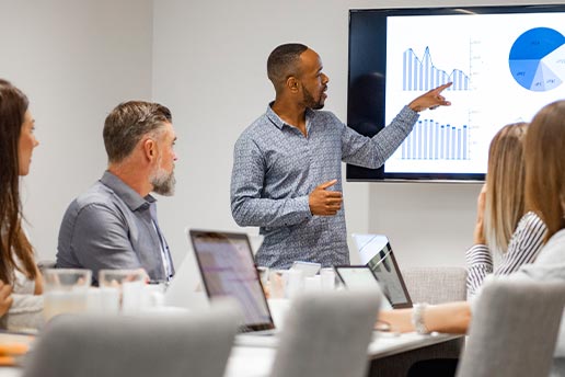 Business people in a meeting, watching a presentation involving data